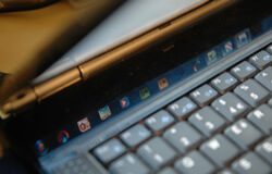 A picture of taskbar icons reflecting on a laptop.